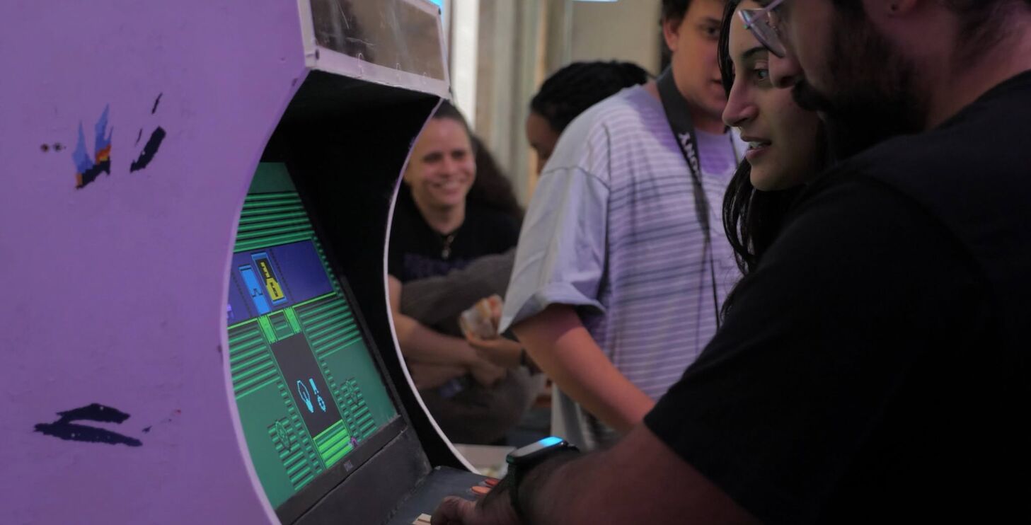 Players and onlookers around the arcade cabinet