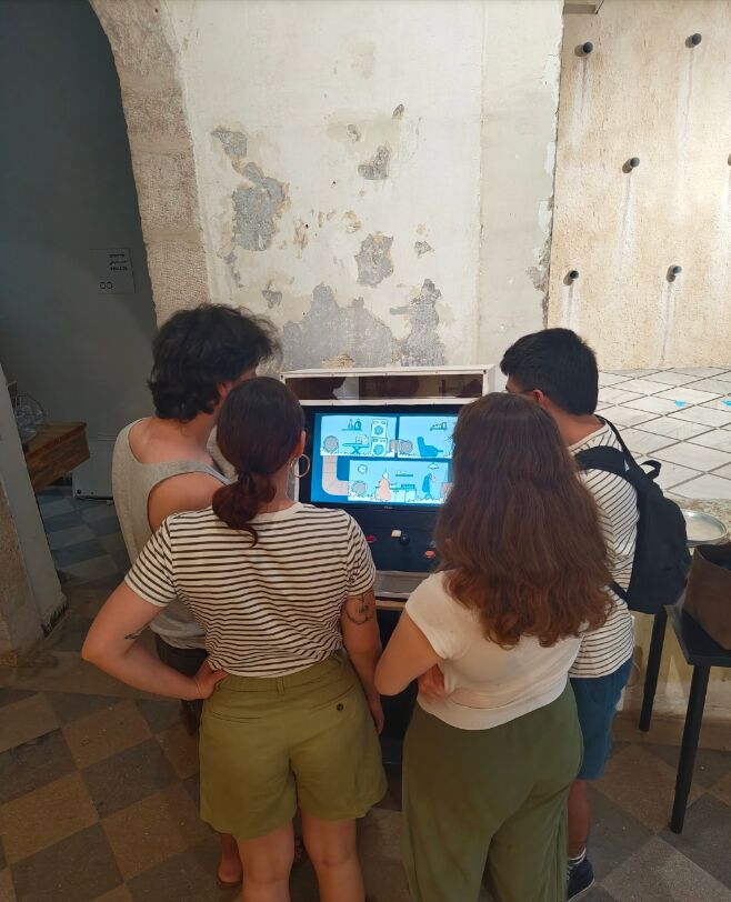 Four visitors gathered around the arcade cabinet