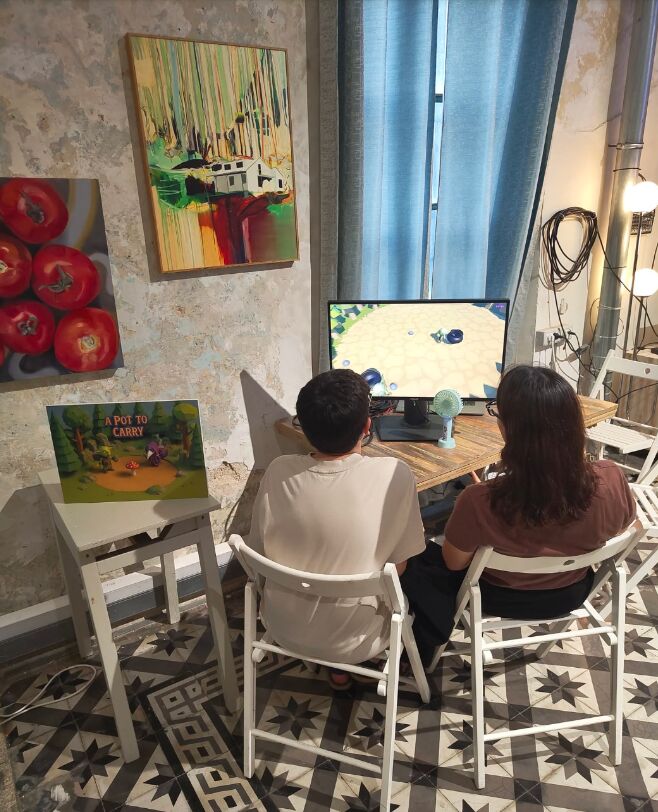 Two players at the A Pot To Carry station